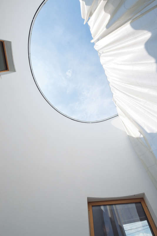 透け感のあるカーテンで緩やかに仕切られた中庭的なテラスが心地よい