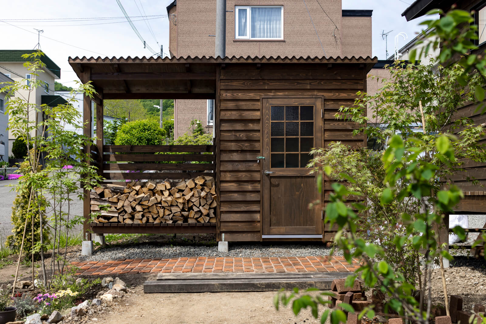 外物置と薪棚を組み合わせたカラマツ材の薪小屋は、カサシマ建設のオリジナル。自社工場で組み立て、庭に設置した